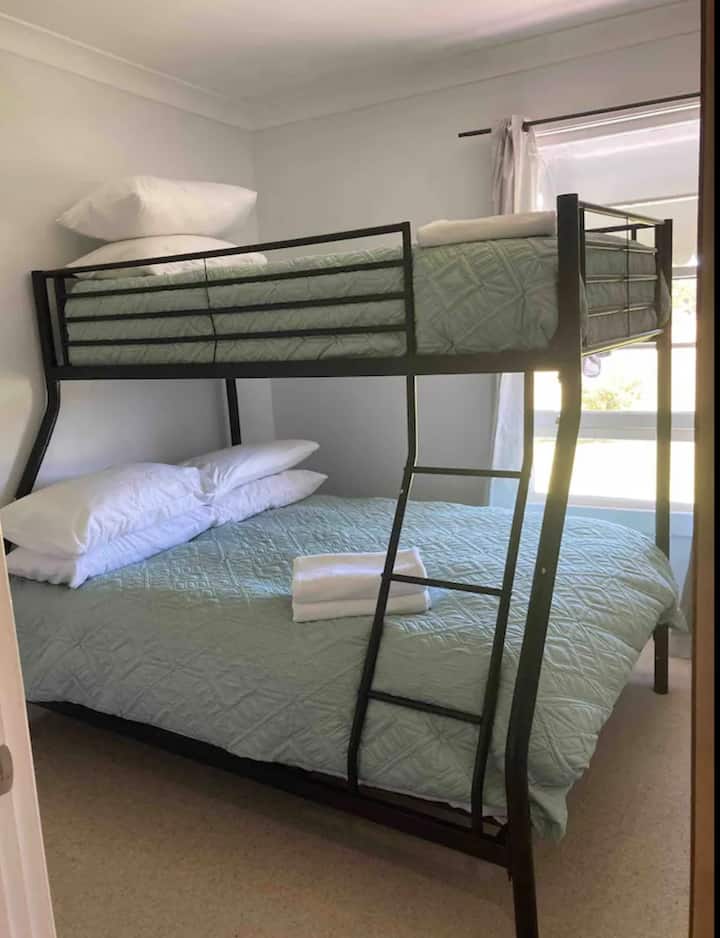 חדר עם מיטת קומתיים בקומה הראשונה. מיטה זוגית בחלק התחתון ומיטת יחיד למעלה