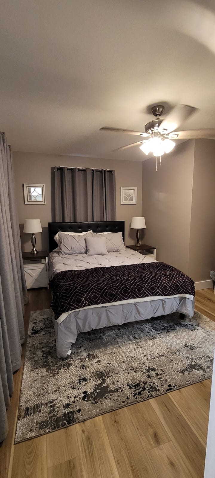 חדר שינה שני עם מיטת קווין סייז ווילונות האפלה.