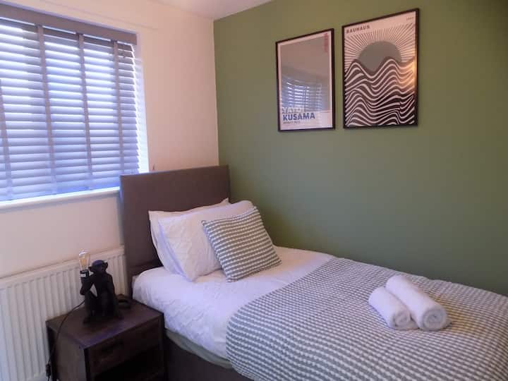 כמו חדרי שינה ליחיד, זה יותר אופנתי מאשר עלוב! מיטת יחיד בגודל סביר, אחסון בגדים, שולחן ליד המיטה עם מנורה סופר מסוגננת ולהירגע בצפייה בטלוויזיה החכמה המותקנת על הקיר! 