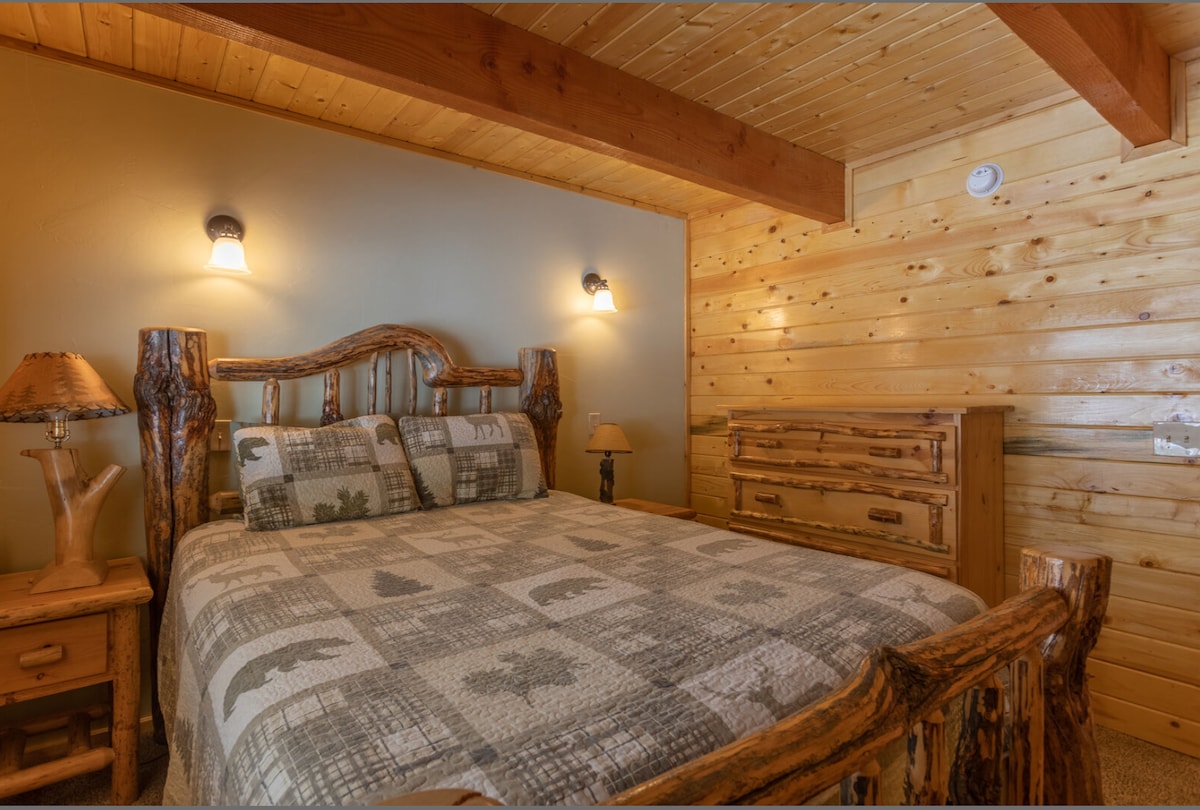 Udobna soba s velikim bračnim krevetom i toplim drvenim elementima u stilu brvnare.