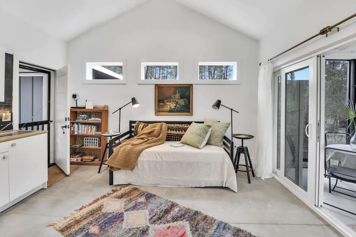 El acogedor sofá cama también tiene cama nido extraíble para ser una cama tamaño king o dos camas individuales. También  disponible para una sala de estar durante el día. ¡Este espacio también tiene un escritorio/silla de trabajo sobre ruedas que puede estar en un porche protegido para contemplar el bosque en una jornada laboral! 