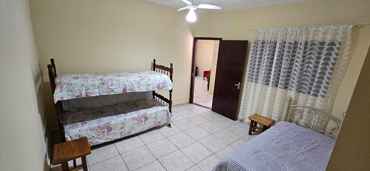 Kamer 02 - Een stapelbed en een 1 persoonsbed, met een plafondventilator.