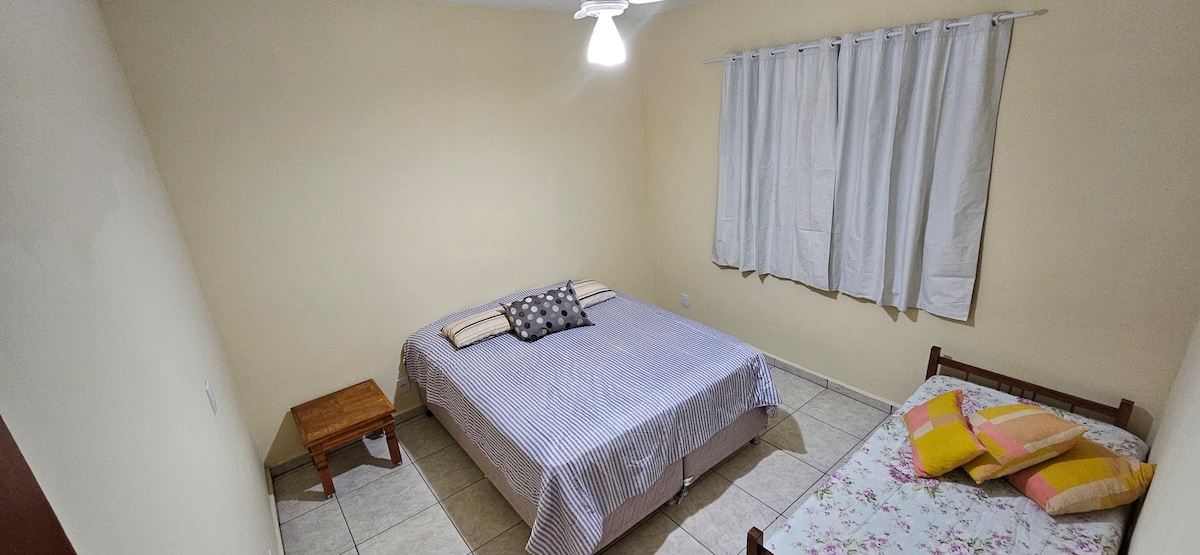 Kamer 01 - Een tweepersoonsbed en een eenpersoonsbed, en een plafondventilator.