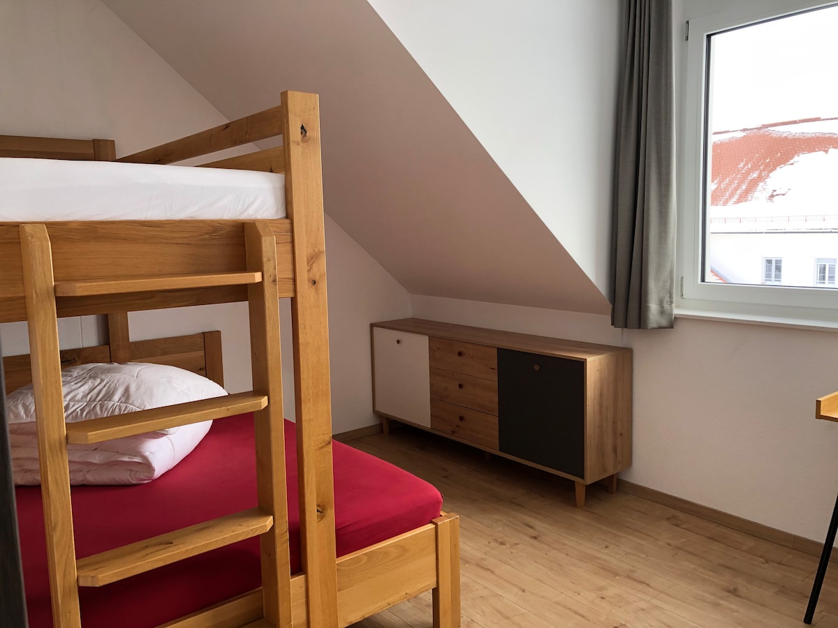 غرفة نوم بسرير مزدوج أصغر في الطابق السفلي وسرير فردي في الطابق العلوي