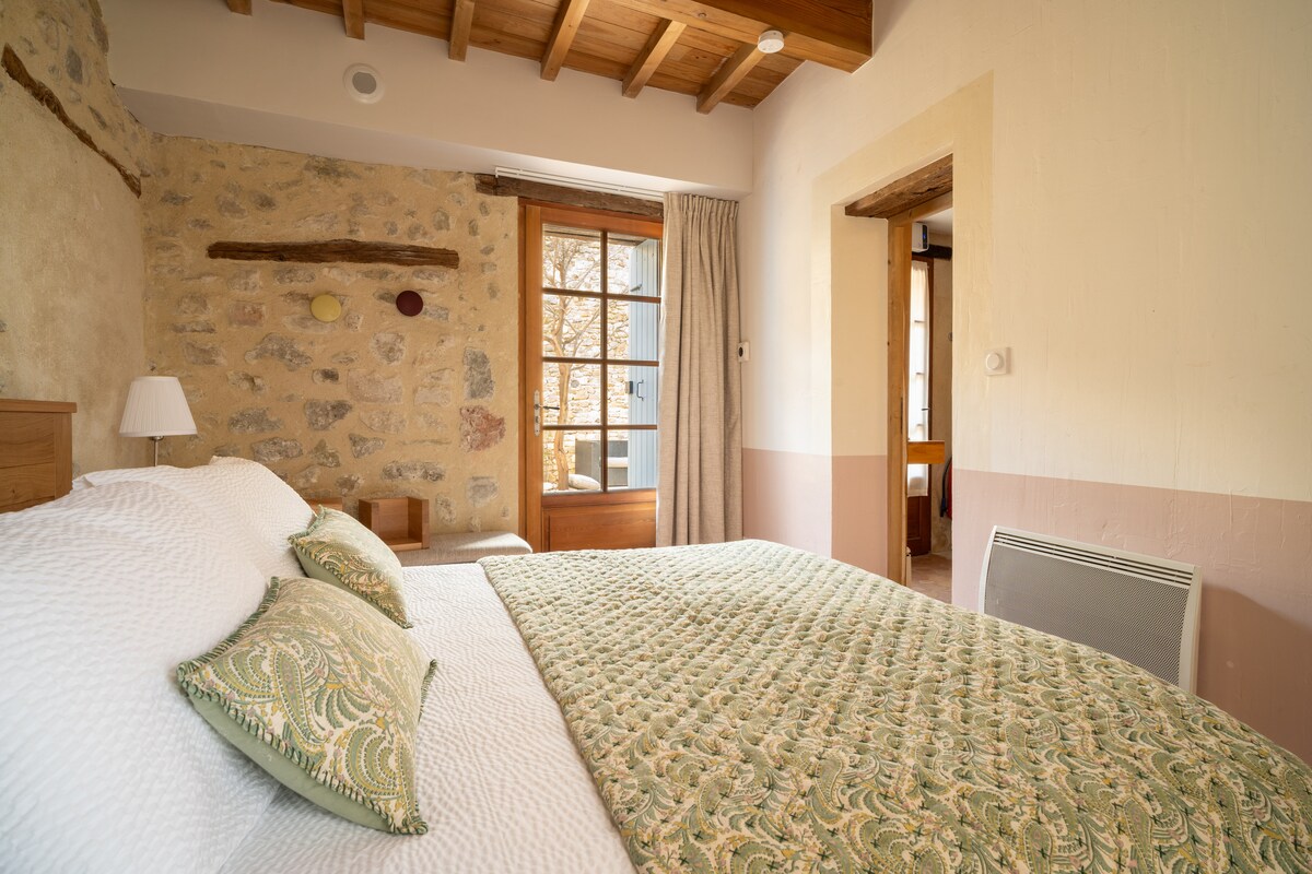 غرفة نوم بسرير 160 سريرًا مريحًا للغاية ومكيفًا وباردًا في الطابق الأرضي يطل على الفناء الحجري مع أثاث الحديقة.