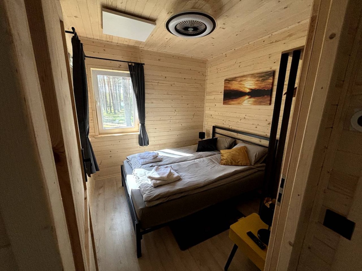 Duża sypialnia z podwójnym łóżkiem, moskitierami w oknach, lampą i wentylatorem sufitowym sterowanymi pilotem oraz niezależnym ogrzewaniem