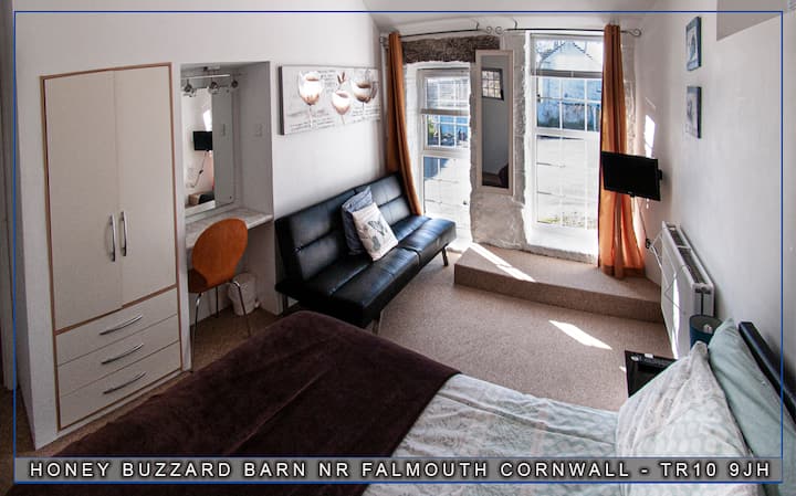 The Master Bedroom, double bed, fitted wardrobe and leather sofa opposite the wallhanging TV. Large room with 2 full length windows looking onto the Courtyard.