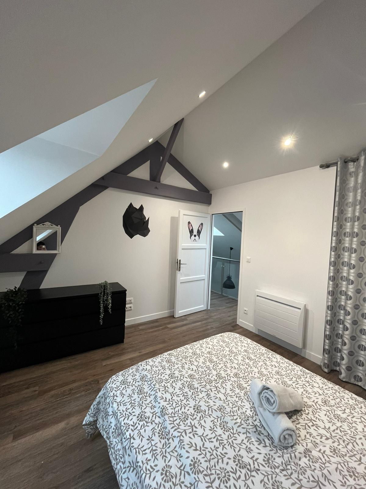 غرفة النوم الأولى بسرير مزدوج وخزانة ملابس لتخزين الملابس وبياضات الأسرّة ومناشف الحمام