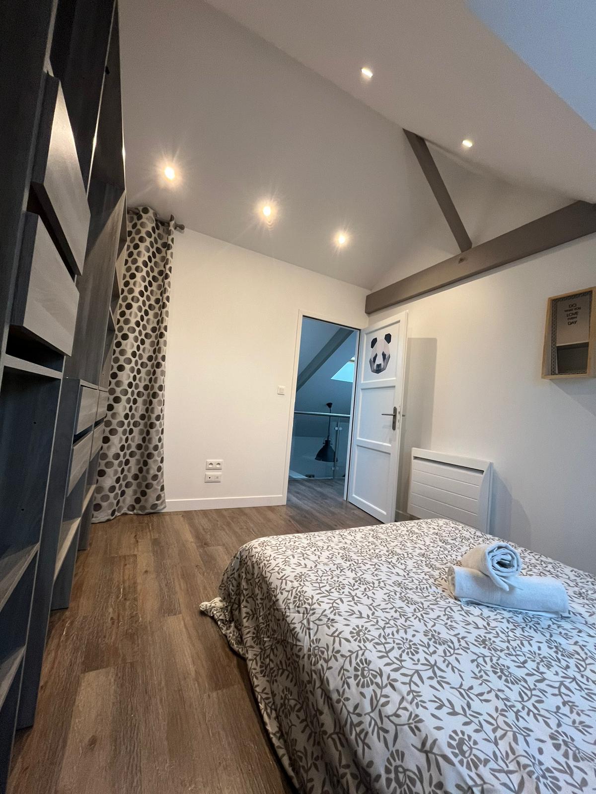 غرفة نوم ثانية بسرير مزدوج وخزانة ملابس لتخزين الملابس وبياضات الأسرّة ومناشف الحمام