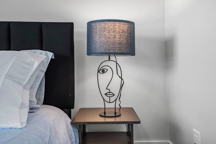 Dormitorio acogedor con mesitas de noche y lámparas

Almohadas cómodas con sábanas nuevas

Almohadas y tiras decorativas