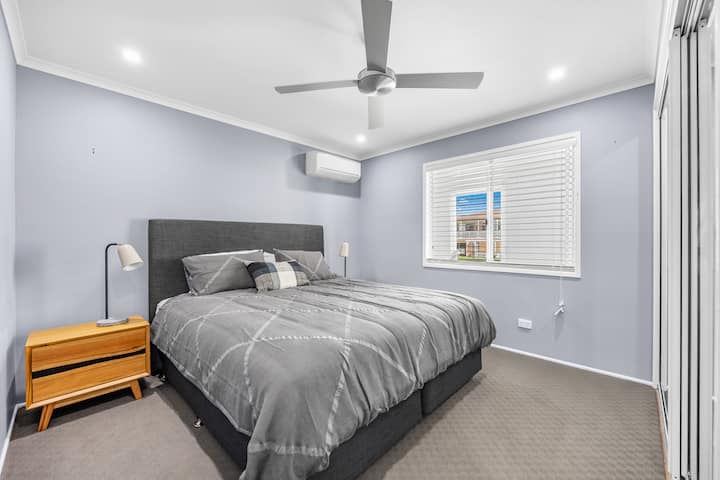 Druhá spálňa zvýrazňuje manželskú posteľ so vstavanými skrinkami a odkladacími stolíkmi so svetlami na čítanie.
