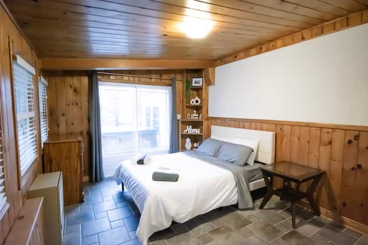 Stort soveværelse med masser af naturligt lys og rustik indretning
