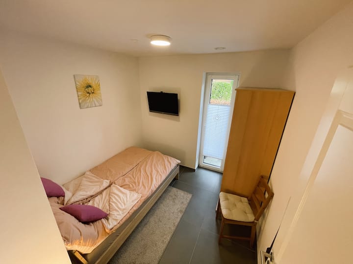 Dormitorio en planta baja 1: cama de 120 x 200 cm incl. Ropa de cama, postre y lámpara de postre, armario con perchas y TV. Persianas eléctricas para el apagón.