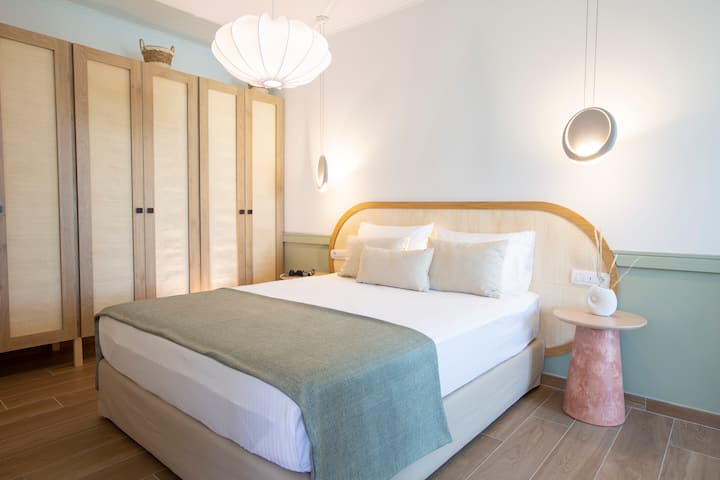 Dormitorio estudio independiente con una cama doble y unidad de aire acondicionado.