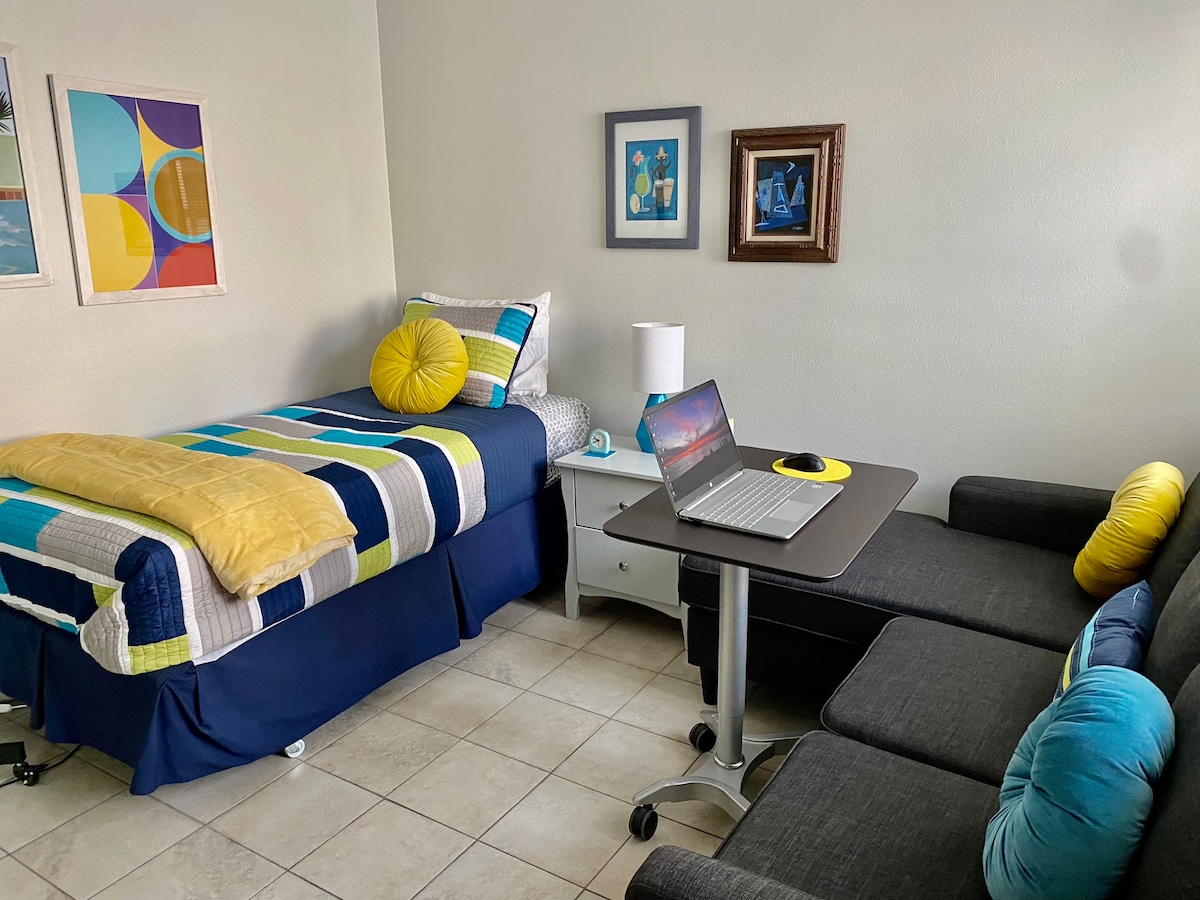 Студио за работа/спална соба за гости со два одделни кревета и кауч, со подвижна прилагодлива количка за лаптоп