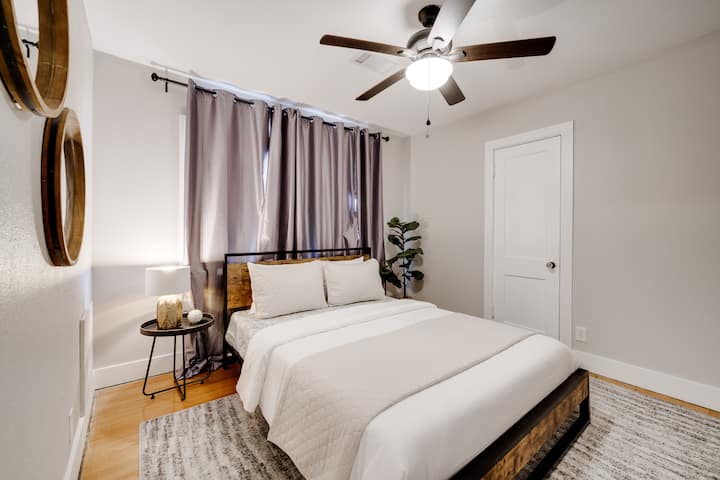 Chambre lumineuse et confortable avec un grand lit, un ventilateur de plafond et une décoration chaleureuse pour un séjour reposant.