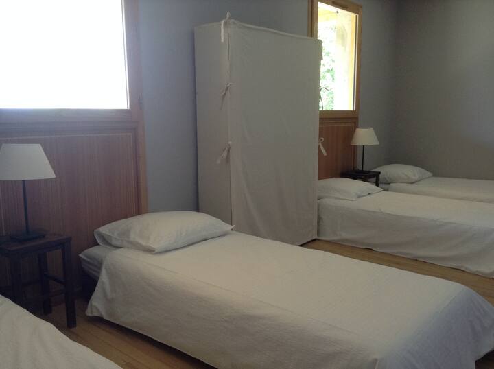 Abajo una amplia habitación ""dormitorio"" consta de 4 camas individuales y su baño equipado con ducha.