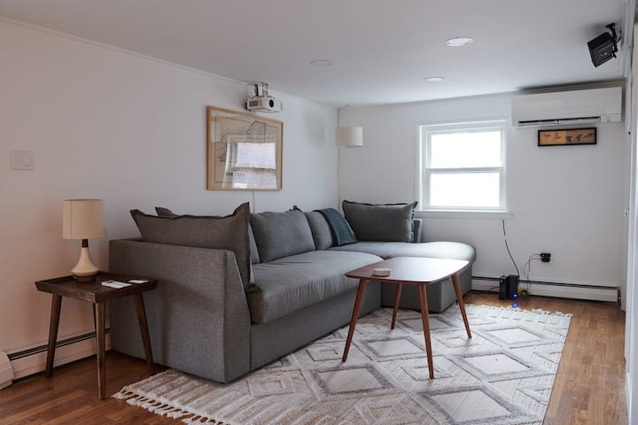 Მყუდრო, თანამედროვე მისაღები ოთახი ხის თბილი აქცენტებით, დახვეწილი დივნით, დიდი ფანჯრებით, რომელიც იძლევა ბუნებრივ განათებას და სოფლის ყავის მაგიდას. Საცხოვრებელი გაფორმებულია ნეიტრალური ტონებით, რაც განტვირთვისთვის მიმზიდველ და მშვიდ გარემოს ქმნის.