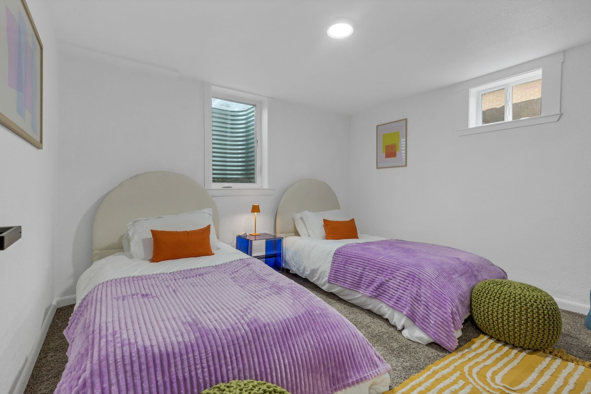 Спална соба со тепих и 2 двокреветни кревета.