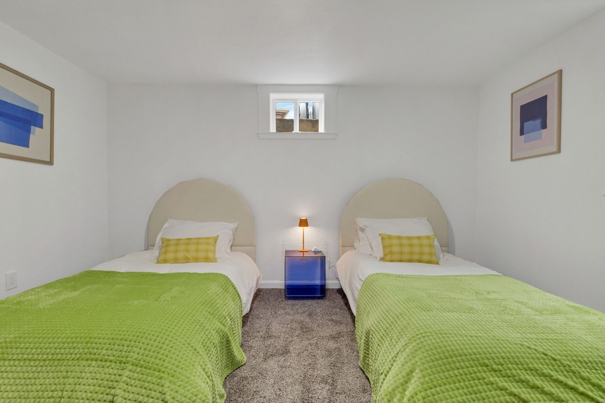 Спална соба со тепих и 2 двокреветни кревета.