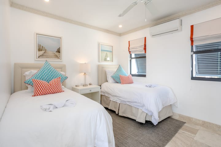 Chumba cha 6 cha kulala kina vitanda viwili na kina kiyoyozi, feni ya dari, mlango wa kuteleza kwenye roshani na suti.