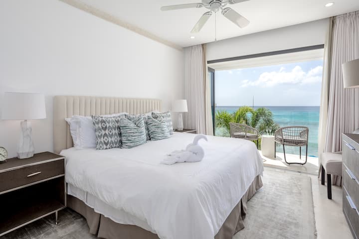 Chumba cha kulala chenye utulivu chenye kitanda cha ukubwa wa kifalme cha Uingereza, roshani ya kujitegemea iliyo na mandhari nzuri ya bahari, kiyoyozi, feni ya dari na chumba cha kulala.