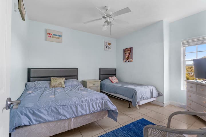 La troisième chambre qui se trouve sur le côté droit à travers le hall depuis la porte d'entrée.  Il contient un lit queen size et un lit jumeau et également une salle de bains commune avec la deuxième chambre.