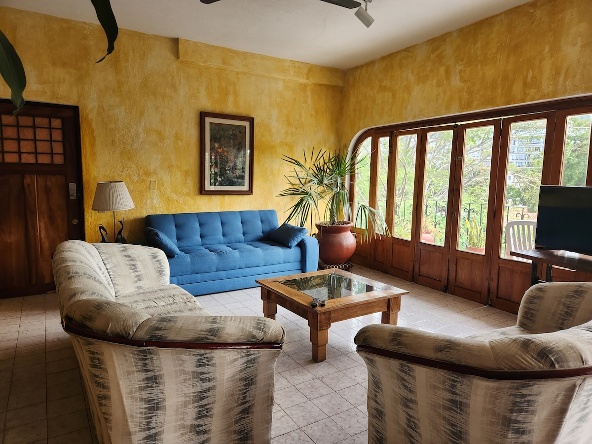 Krásna izba s oknom a balkónom s výhľadom na rieku má modrú rozkladaciu pohovku pre dve osoby.