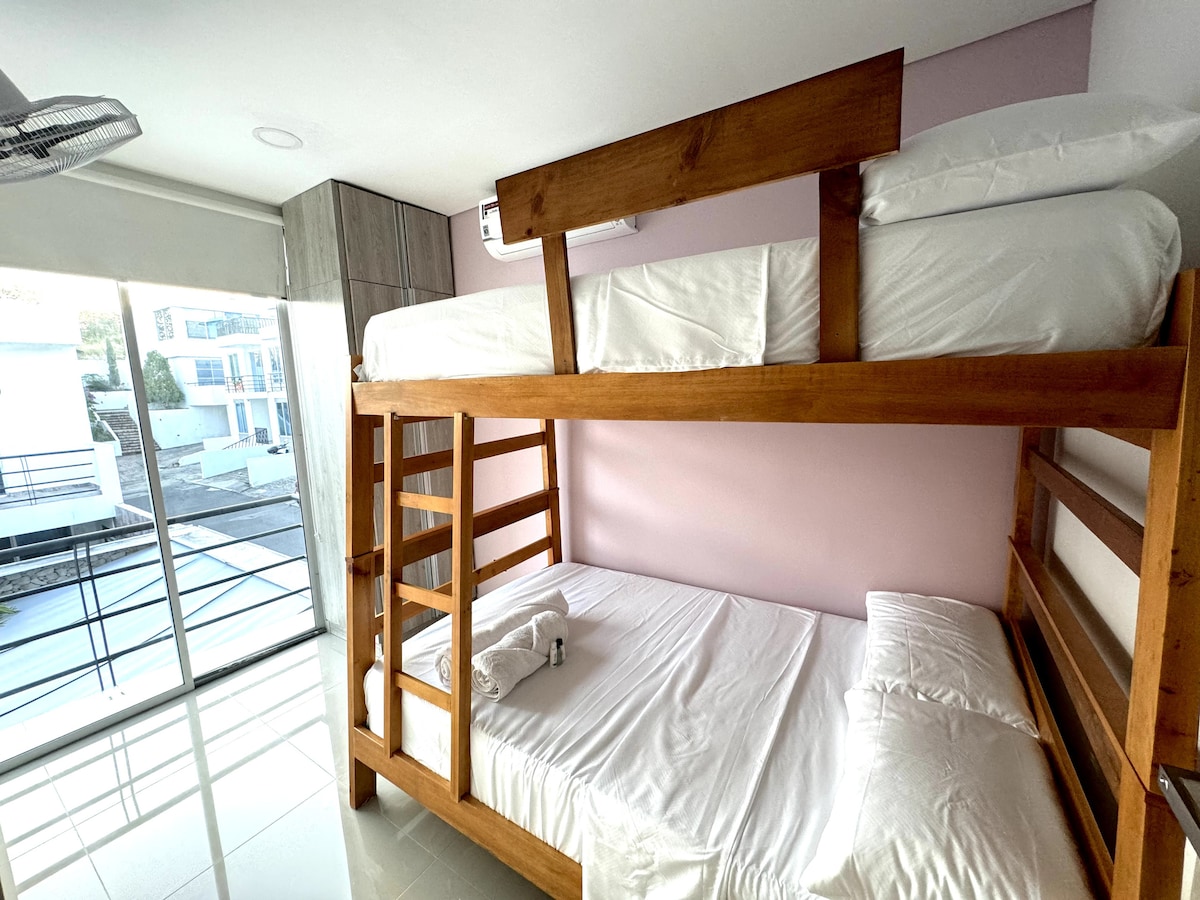 Habitación segundo piso con un camarote familiar, cuenta con aire, con ventilador de pared y un baño compartido.