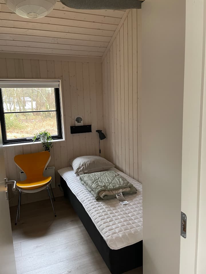 Kamer met 2 enkele bedden en 1 kledingkast met planken.