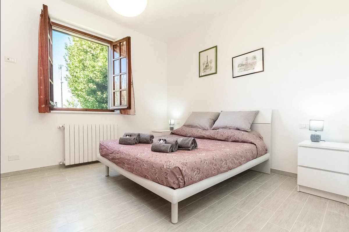 غرفة نوم في الطابق السفلي مع مكيف هواء. مشرق ومريح مع إطلالات على المساحات الخضراء. سرير مزدوج أنيق مع الاهتمام بالتفاصيل، مثالي للاسترخاء في هدوء تام