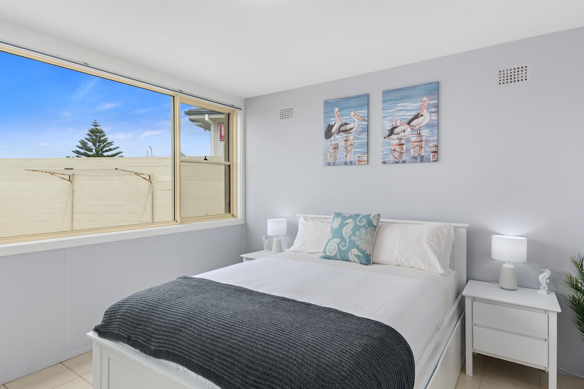 The primary bedroom comes with a comfortable queen-sized bed, set with side tables and reading lights.
