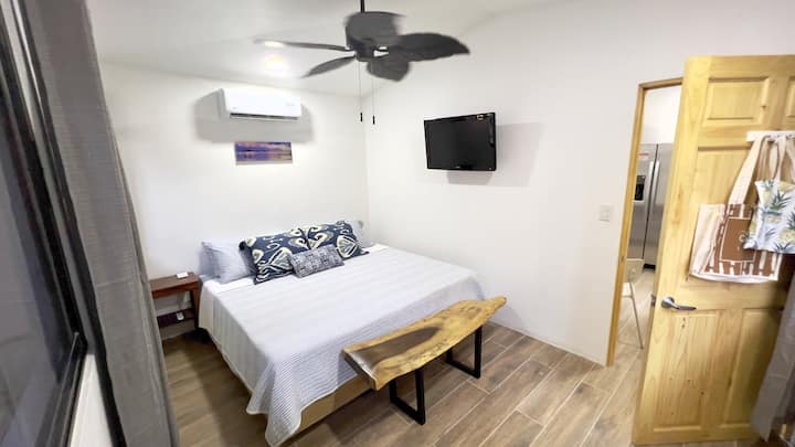 Kitanda cha ukubwa wa kifalme. Televisheni mahiri ya Wi-Fi iliyounganishwa ukutani karibu na kitanda.