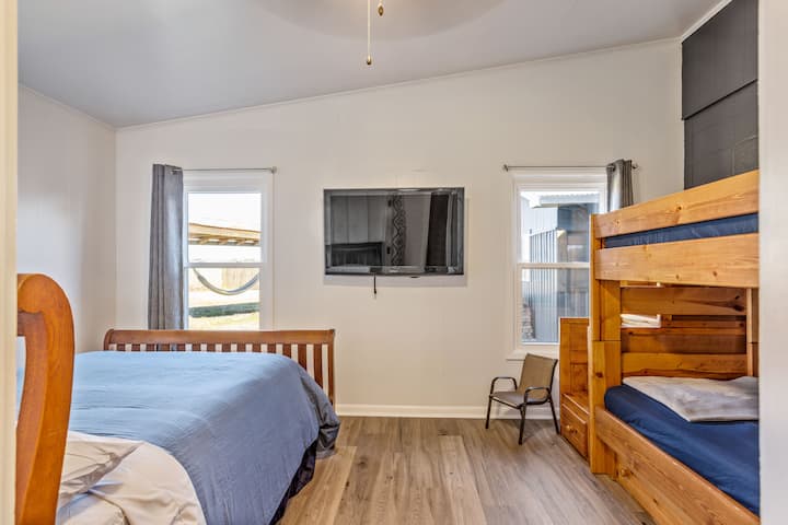 Chumba cha kulala cha wageni chenye mwangaza wa asili kilicho na dari iliyopambwa kina kitanda cha ukubwa kamili na kitanda thabiti cha ghorofa cha ukubwa wa mapacha kinachoangalia nje kwenye sehemu tulivu ya kitanda cha bembea nje. Televisheni inajumuisha plagi ya HDMI ya mcheza michezo ya kompyuta iliyo tayari kuunganishwa kwa saa za kujifurahisha! 