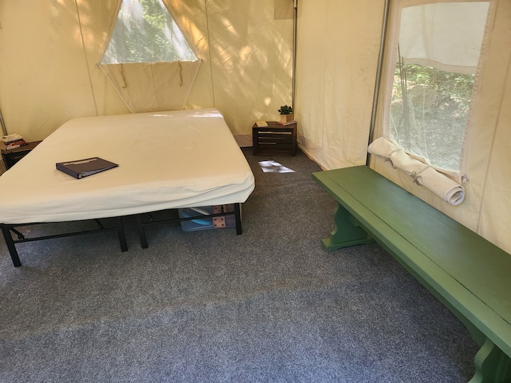 Queen size bed-guest bring their own bedding, 2 side tables, a bench, indoor/outdoor carpet