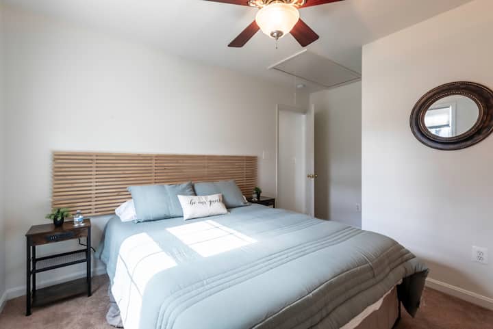 Queen bed with extra pillows and blanket; outlet plug on each night stand.