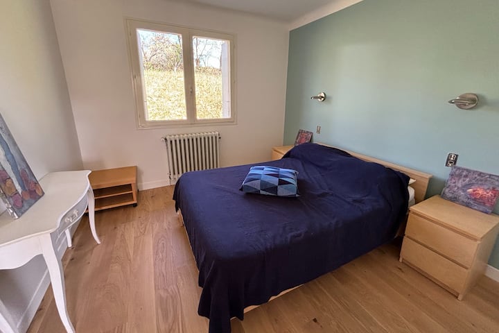 Chambre avec lit double, vue sur jardin.