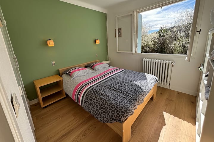 Chambre avec lit double, placard, vue sur jardin.