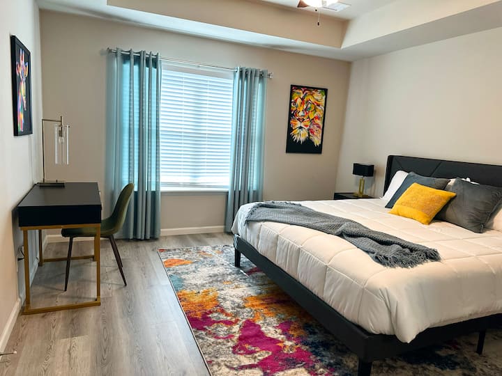 חדר שינה ראשי עם מיטת קינג סייז ושולחן עבודה.