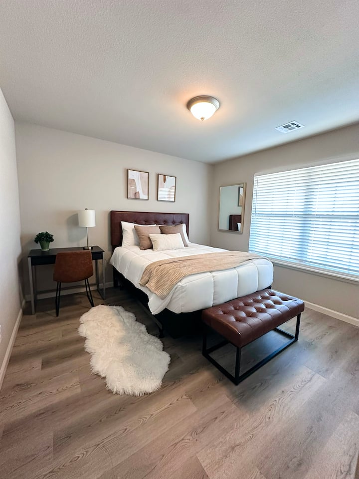 חדר שינה 1 עם מיטת קווין סייז ושולחן כתיבה.