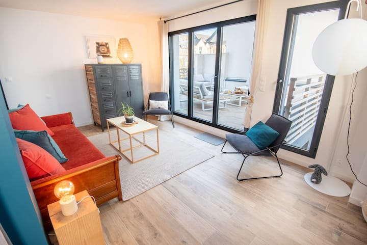 Sebule ya ghorofa ya 1 iliyo na sofa, viti vya mikono, meza ya kahawa na ufikiaji mkubwa wa mtaro.  Chumba hiki kina vitanda viwili vya ziada.