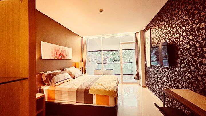 Private 41m² studio room: king bed, AC, TV, work desk, clothing cabinet, and balcony with pool views.