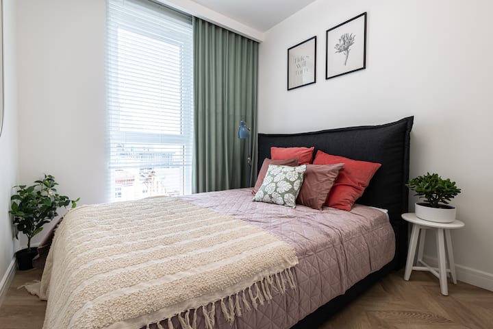 เตียงขนาดใหญ่ในห้องนอน ด้านนอกหน้าต่างมีวิวโอเปเร