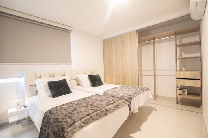 Spavaća soba 3 na gornjoj etaži s 2 velika kreveta za jednu osobu, ormarom i roletama za zamračivanje. Kupaonica sa spojenom kupaonicom nije vidljiva na fotografiji. 