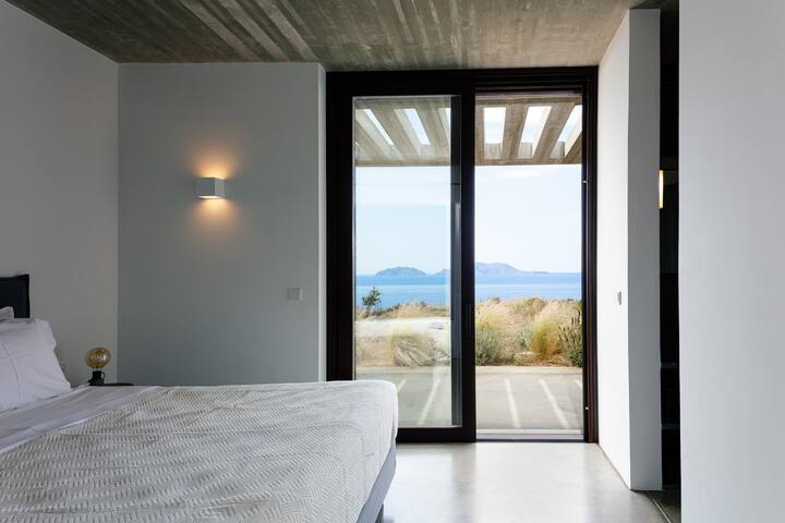 غرفة النوم المزدوجة الثانية، التي تتميز أيضًا بإطلالات على البحر وسرير بمقاس كبير مع حمام داخلي. 