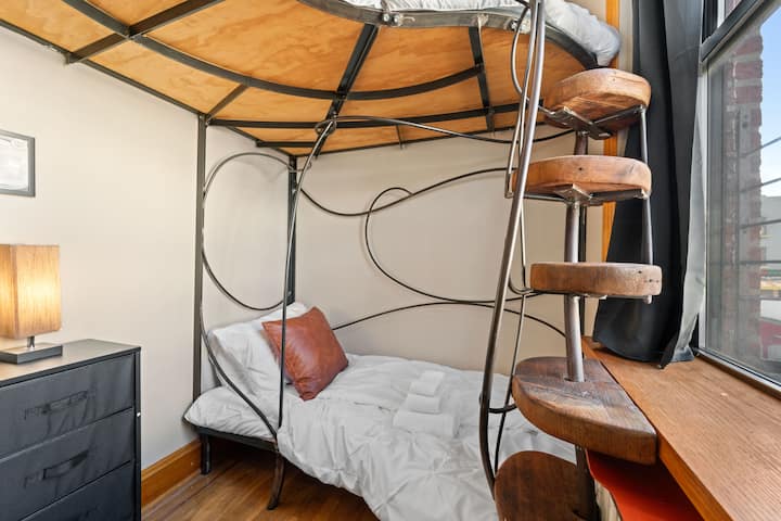 Ova spavaća soba očarava svojim neobičnim i modernim dizajnom kreveta na kat, gdje zakrivljeni metalni okviri daju umjetnički dojam prostoru – idealno za djecu, ali mogu spavati i odrasli.