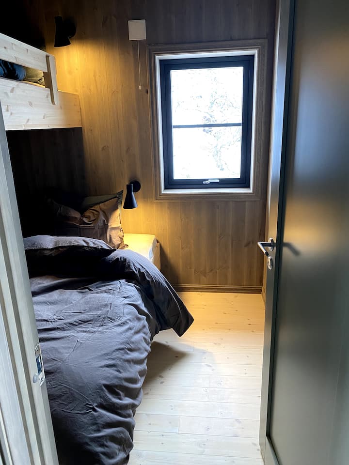 Спалната соба на викендичката свртена кон север има двоен кревет со еден кревет над неа. Тоа е бидејќи фотографијата е направена, поставени се звучни завеси во сите соби за да се осигура спиењето. 