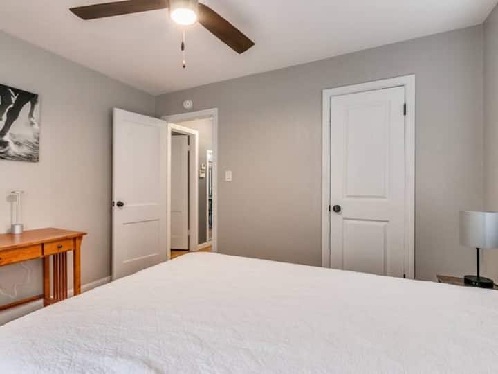 ห้องนอนรองพร้อมเตียงขนาดใหญ่และโต๊ะทำงาน