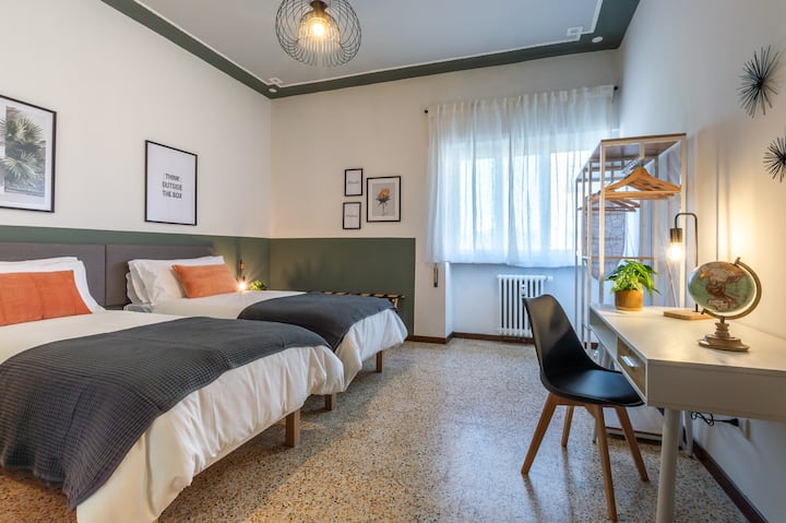 חדר זוגי עם 2 מיטות יחיד נוחות ומימין שולחן עבודה