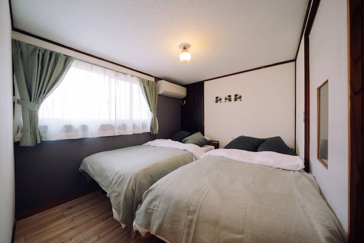 シングルベッド2台、エアコンがある寝室です。枕元にはコンセントがあり、スマートフォンの充電に便利です。